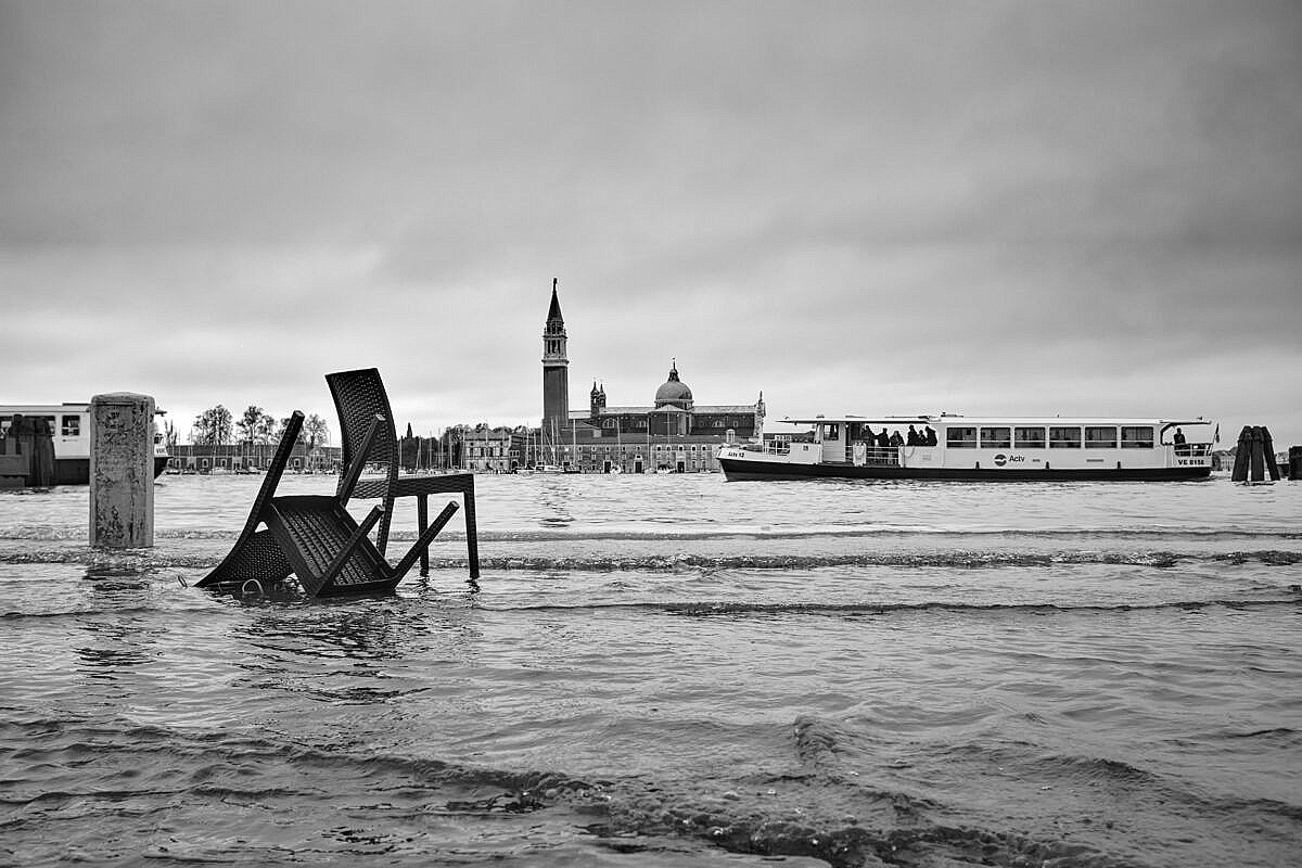 High tide in Venice - abandoned furniture with vaporetti.