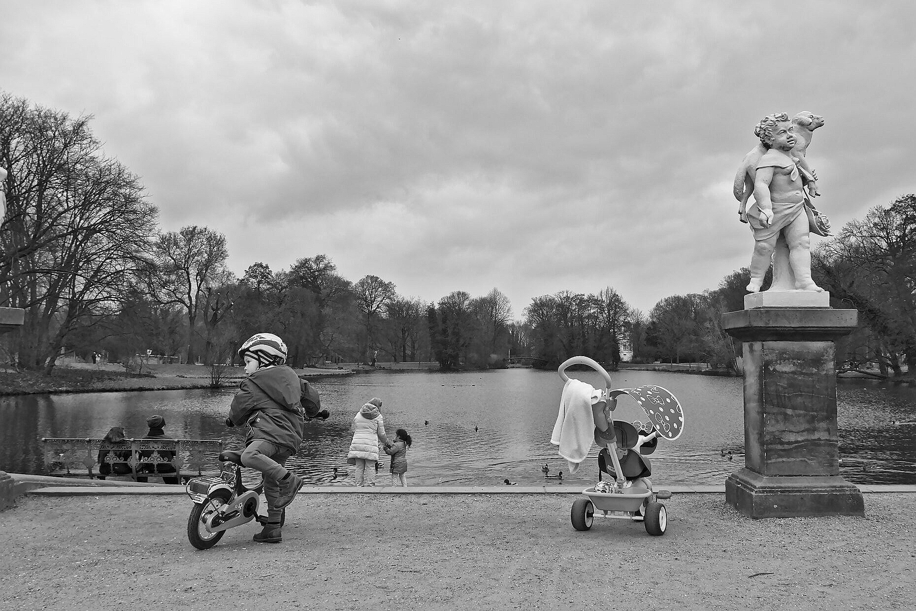 A young boy unmounting his bicycle in the garden of Schloss Charlottenburg