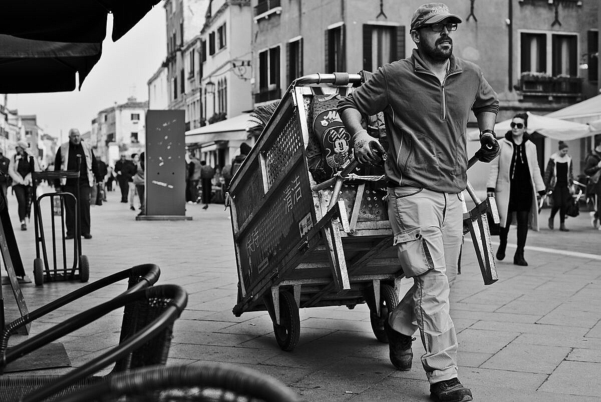 Garbage collector in the Via Garibaldi with his hand drawn cart.