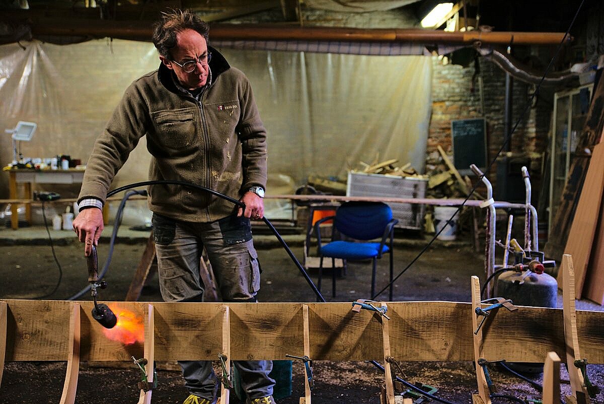 The flanks of a gondola are made of oak planks which have to be bend into shape using heat and water